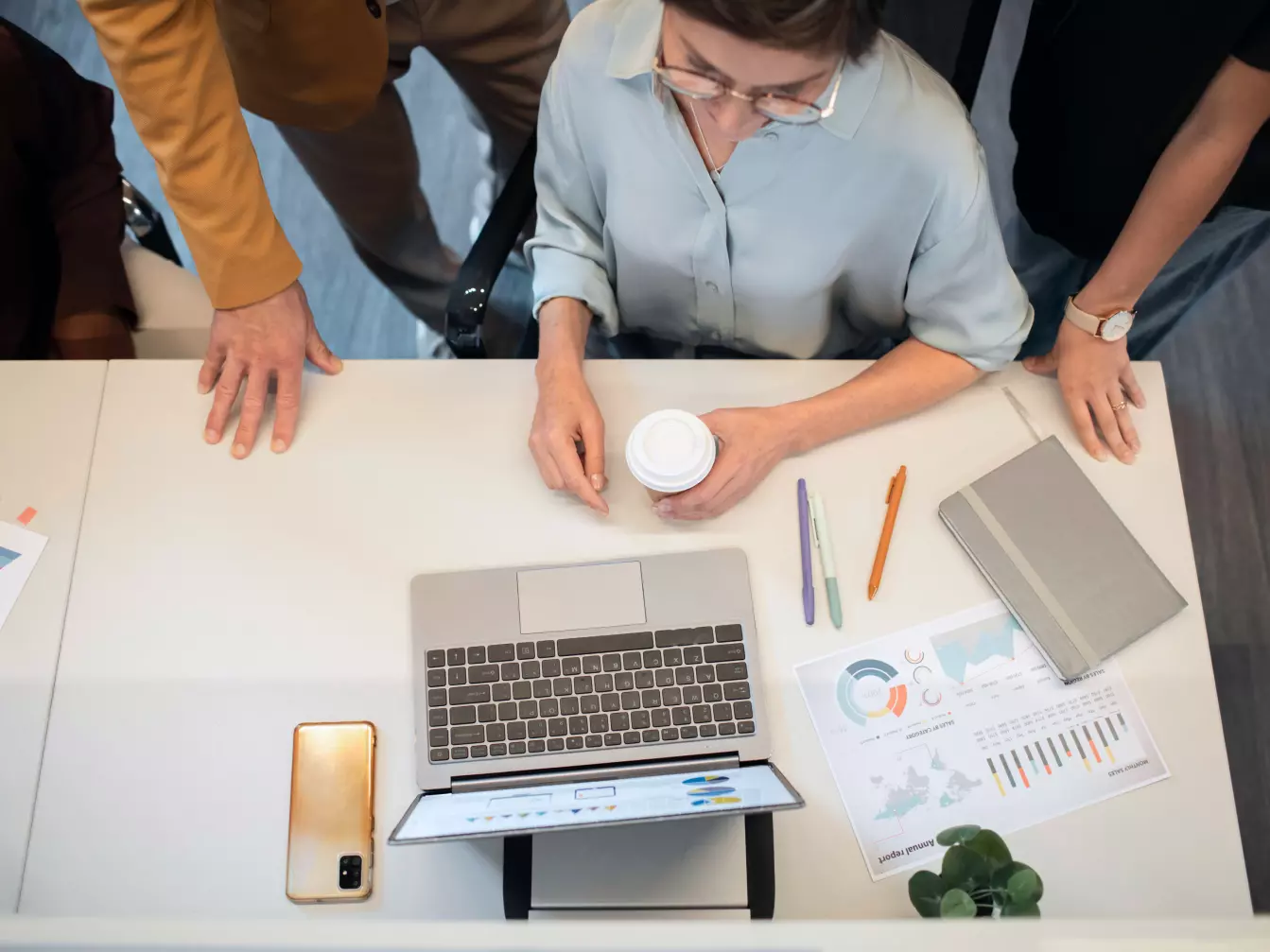 Trzy osoby analizujące wyniki na laptopie